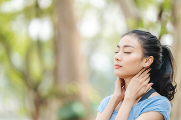 Asian woman stretching body and neck after jogging exercise at park in the city. Attractive athlete girl in sportswear enjoy outdoor lifestyle sport training fitness running workout in morning summer