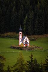 Val Di Funes, Dolomites, Italy - The beautiful St. Johann in Ranui Church at South Tyrol in the Italian Dolomites with green pine trees