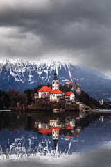 Bled, Slovenia - Beautiful view of Lake Bled (Blejsko Jezero) with reflecting Pilgrimage Church of the Assumption of Maria on Bled Island, Bled Castle and Julian Alps at background at winter time