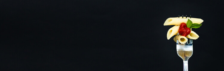 Minimal macro photography of paste with tomato sauce on fork on black background with copy space....