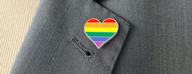 Closeup of LGBT flag pin attached to business suit