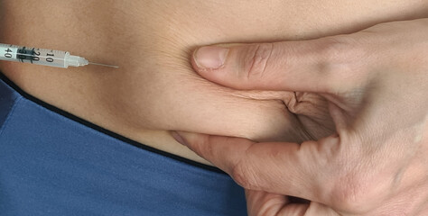 Woman makes an injection of hormone therapy in abdomen