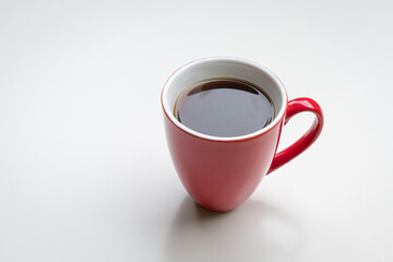 Coffee in red cup, isolated on white background. Copy space.