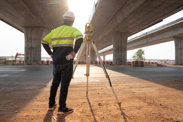 Surveyor site engineer installing tacheometer above control point before performing setting out for...