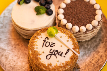 Three bento cakes with different designs on a yellow background.