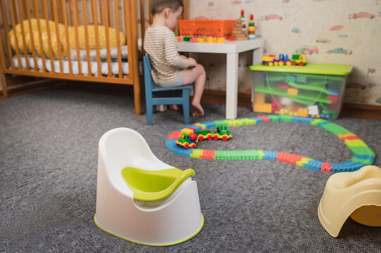 The pot stands in the children's room against the background of a playing child and toys