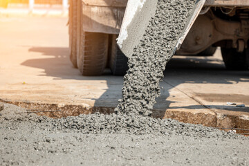 Pouring ready-mixed concrete after placing steel reinforcement to make the road by mixing in...