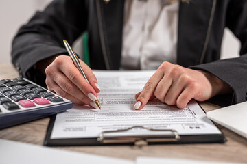 businesswoman filling out the 1040 tax form 2022. financial paperwork concept