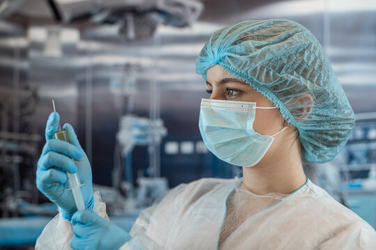 Feamale anesthesiologist prerape injection epidural analgesia standing in emergency surgery room