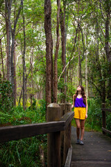 Naklejka na ściany i meble Beautiful girl in colorful clothes andmires and walks in Brisbane Koala Bushlands Park, Queensland, Australia