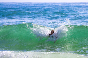 Happy girl ejnoy catching waves at beautiful intimate second bay near Coolum beach, Sunshine Coast, Queensland, Australia