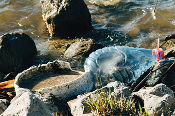 River water pollution as environmental damage, plastic bottles littering the freshwater