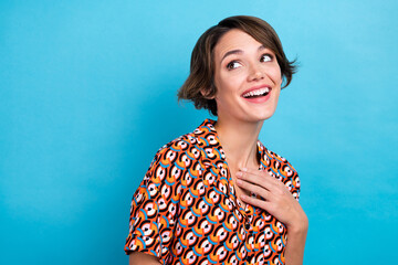Photo of sweet dreamy lady dressed print shirt smiling looking back empty space isolated blue color background