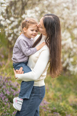 Fototapeta premium Young mother and her cute daughter having a fun in spring time park Petrin in Prague, Europe