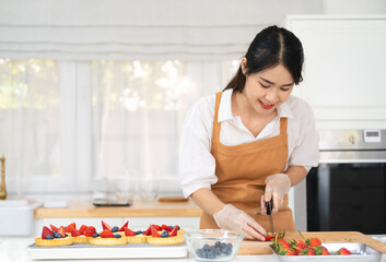 Freshly baked tart with blueberries strawberry fresh fruit kitchen for dessert.Young beautiful woman is baking in kitchen , bakery and coffee shop business.  bakery and coffee shop business.