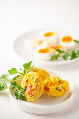 Egg muffins ( bites) and parsley leaves  in a plate on a gray background.