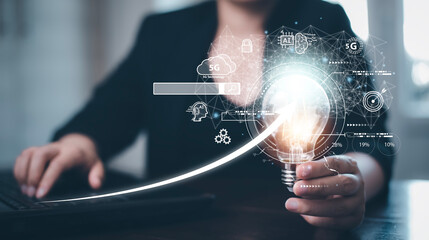 Businessman holding glowing light bulb with AI Data Management System on the computer, Hands working on a laptop cloud network graphic overlay, connected to the database. Corporate strategy finance