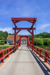 Fototapeta na wymiar Red wooden bridge leading to the historic town of Bourtange, Netherlands