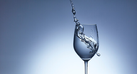 Studio shot of clear water pouring into wineglass