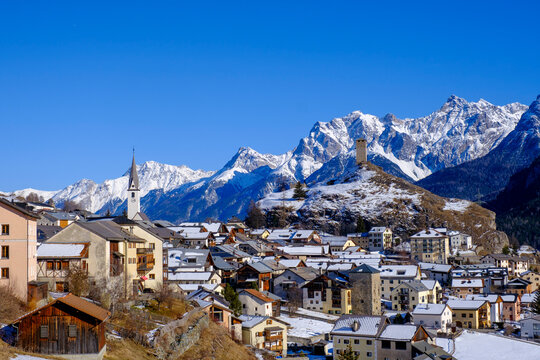 Switzerland, Graubunden Canton, Ardez, View of winter town in Engadine valley with mountains in background