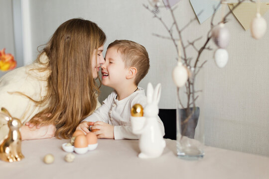 Happy woman rubbing nose with son at home