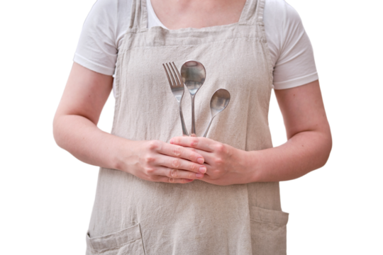 Spoons and forks in the hands of a woman in the kitchen, isolated on a white background. Women's hands hold cutlery for food