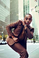 Handsome african american man in suit posing on modern city background