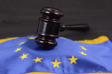 Judge Gavel and European Union flag on a black wooden background.
