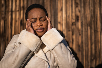 Fototapeta na wymiar Outdoor portrait of african-american woman. She is tired and having headache.