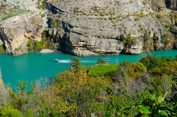 A boat at a canyon river in the high rocky mountains. 