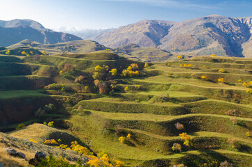 Mountain landscape with green agricultural terraces on the slopes in the Caucasus mountains.