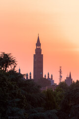 Sunset over Cremona with the imposing silhouette of the Torrazzo, bell tower of the Cathedral in beautiful market square Piazza Duomo. Lombardy, Italy.