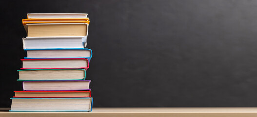 Stack of books on desk with chalkboard © evgeeenius