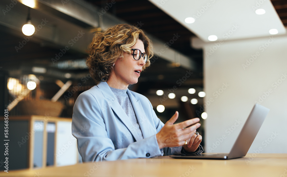 Wall mural business woman talking on a video call in a coworking office