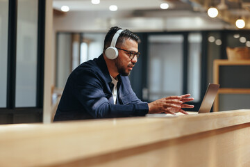 Business man talking on a video call with his team in a coworking office