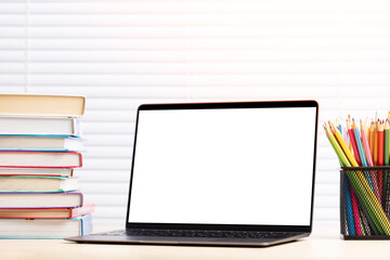 Laptop, books and pencils on desk