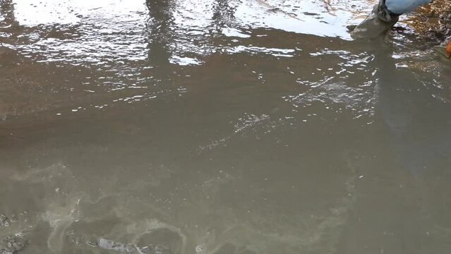 high angle of construction worker's gloved hands using trowel to scrape excess mix level, Construction concept.