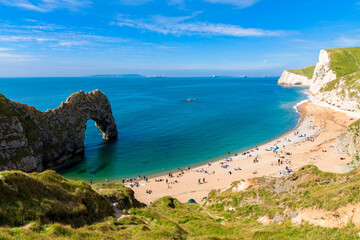 Durdle Door natural arch with its bay and beach. Clear sea water near Lulworth, Jurassic Coast, Dorset, south of England.