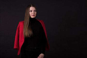 Portrait of a businesswoman in a red suit on a black background.