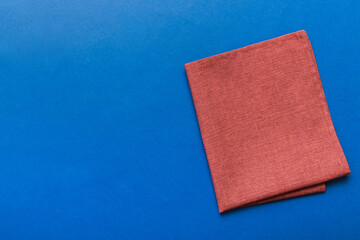 top view with red empty kitchen napkin isolated on table background. Folded cloth for mockup with copy space, Flat lay. Minimal style