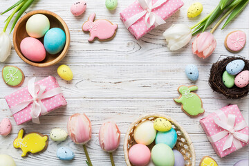 Easter frame with eggs, gift box and tulip on a colored background. The minimal concept. Top view Happy Easter composition. Card with a copy space of the place for the text