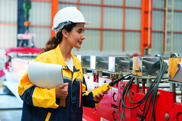rofessional female worker supervising metal sheet forming machine, highlighting technical skills...