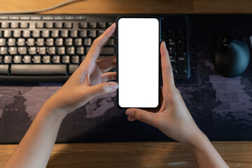 Close up over shoulder view of young businessman using mobile phone in office room, horizontal smart phone with blank screen