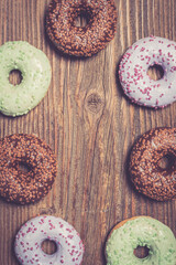Colorful donuts on wooden table