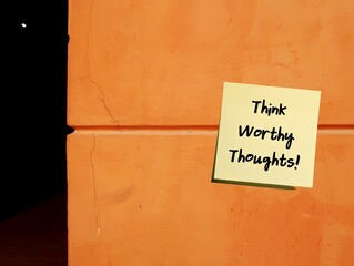 Self reminder note stick on copy space wall with handwriting Think Worthy Thoughts!, means learning...