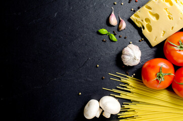 Spaghetti ingredients over dark background