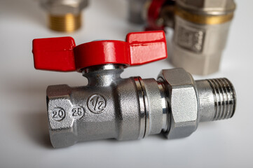 close up view brass metal hanging faucets with red valve differential isolated on light background plumbing connection
