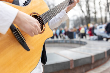 Practicing in playing guitar close up. Street musician playing guitar