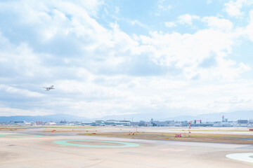 福岡空港の滑走路を離陸して青空に飛んでいく旅客機