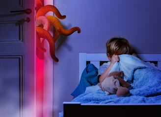 Boy in bedroom hide under blanket from nightdream monster